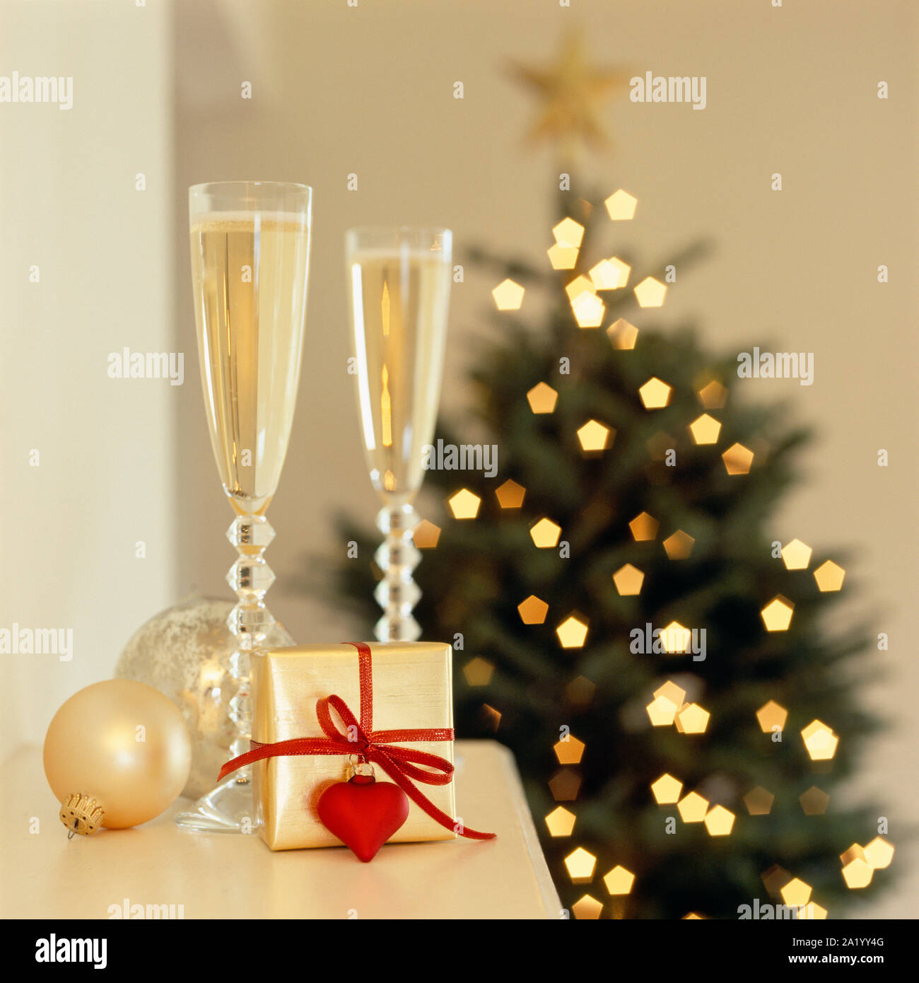 Gläser Champagner Sekt mit romantischen Weihnachtsgeschenk auf Mantel und  Weihnachtsbaum im Hintergrund. Elegante Ferienhaus Interieur  Stockfotografie - Alamy