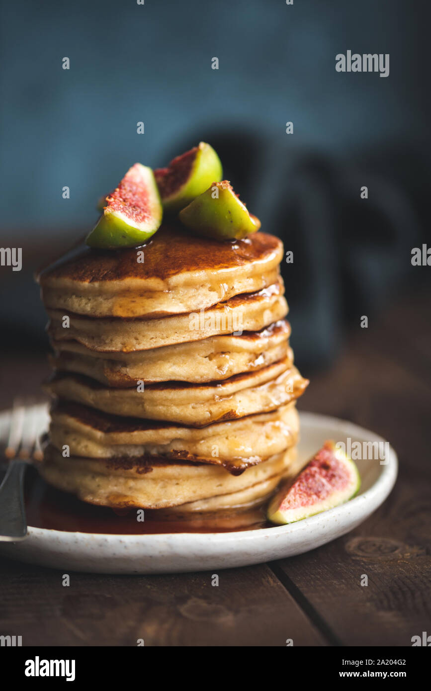 Stapel Pfannkuchen mit Feigen und Sirup auf Holztisch, getönten Bild. Lecker Herbst frühstück Komfort Essen Stockfoto