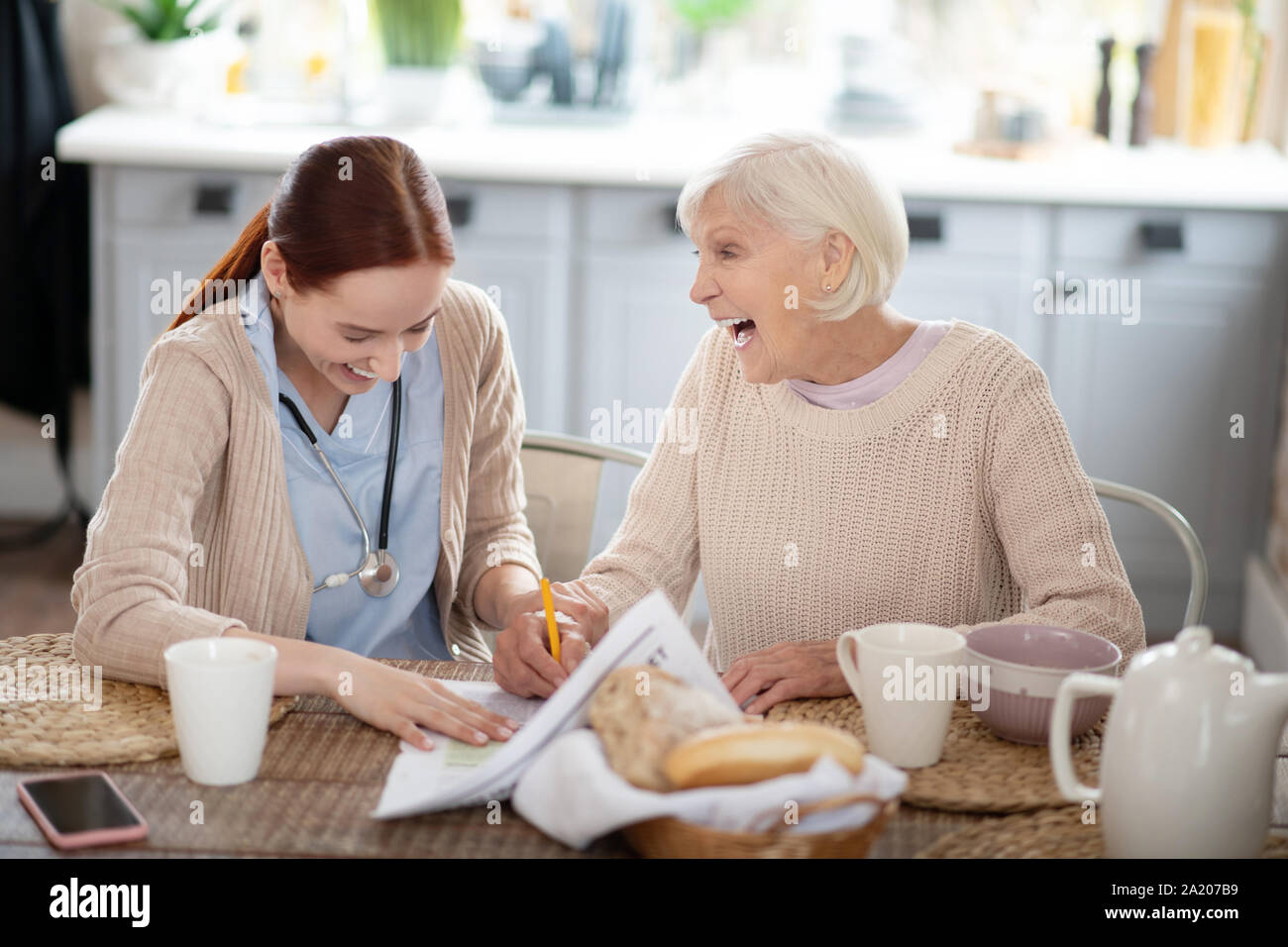 Betreuer und ihre Patienten Lachen beim Lesen von Nachrichten Stockfoto