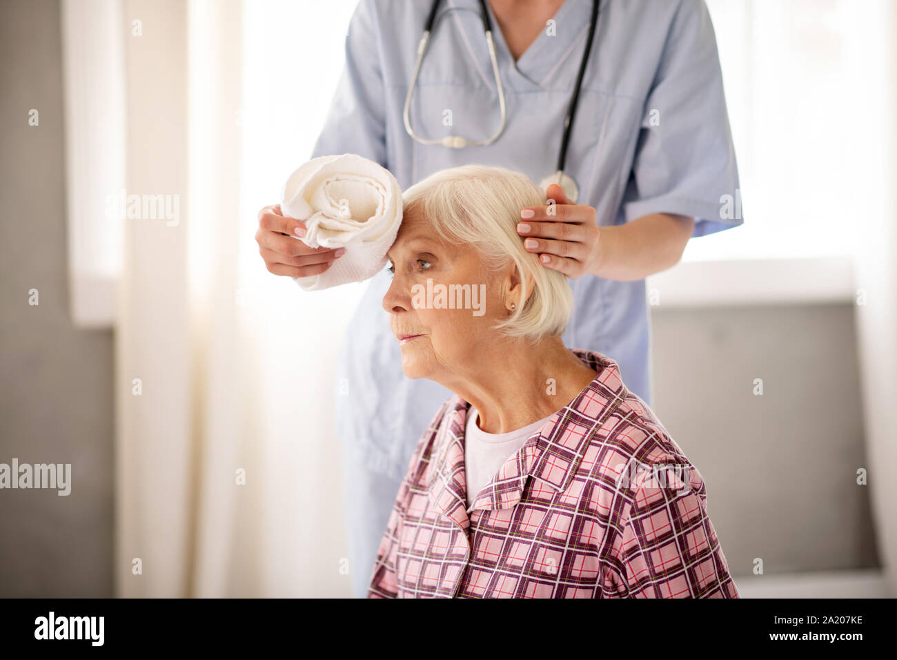 Grauhaarige Frau mit starken Kopfschmerzen Stockfoto