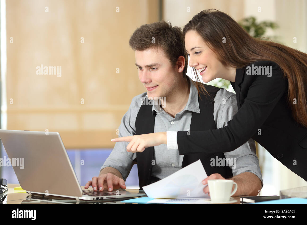 Happy Geschäftsfrau, laptop Inhalte zu ihrer Kollegin im Büro Stockfoto