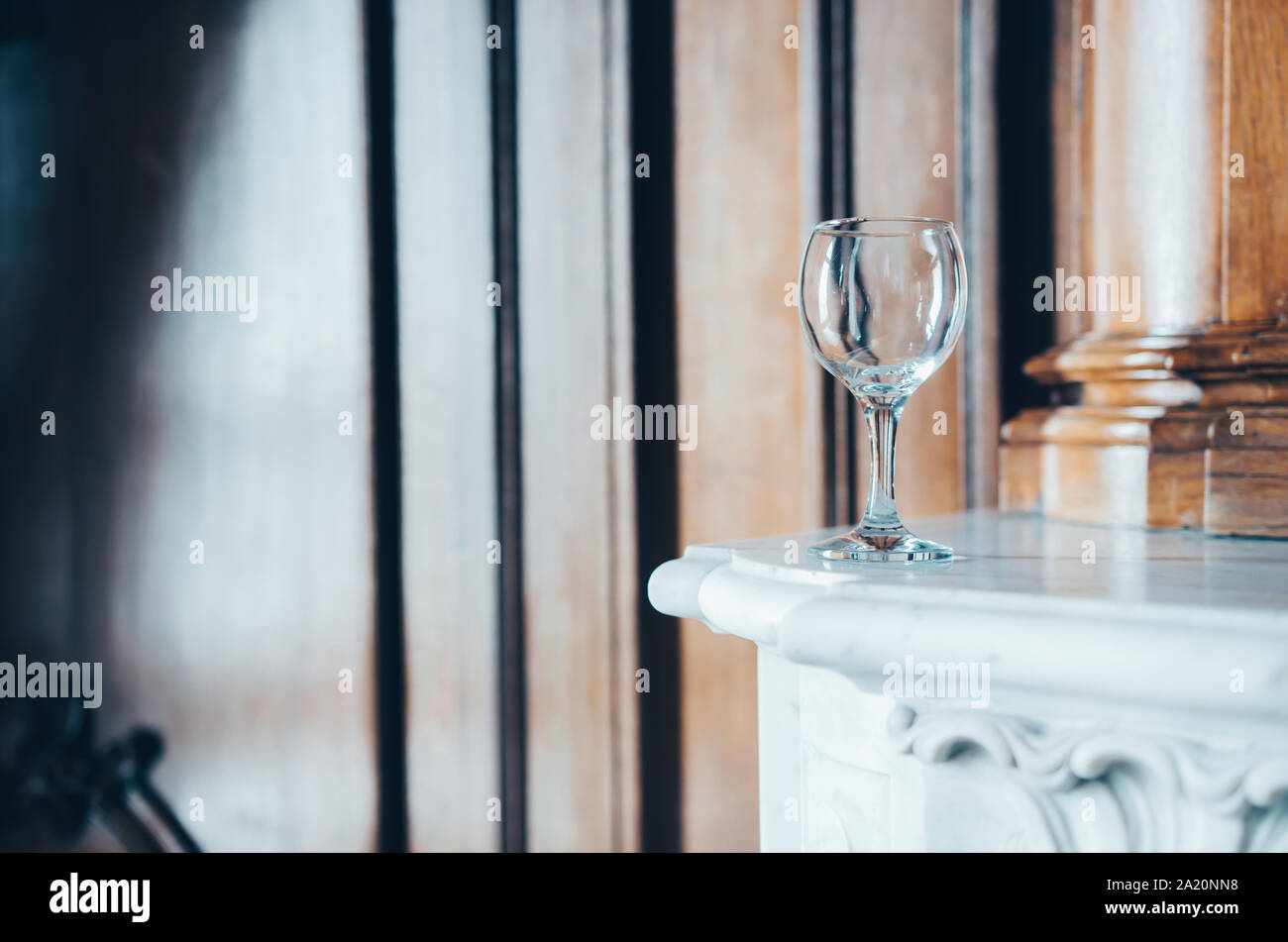 Leere Weinglas auf dem Kaminsims in einem schönen Interieur Stockfoto