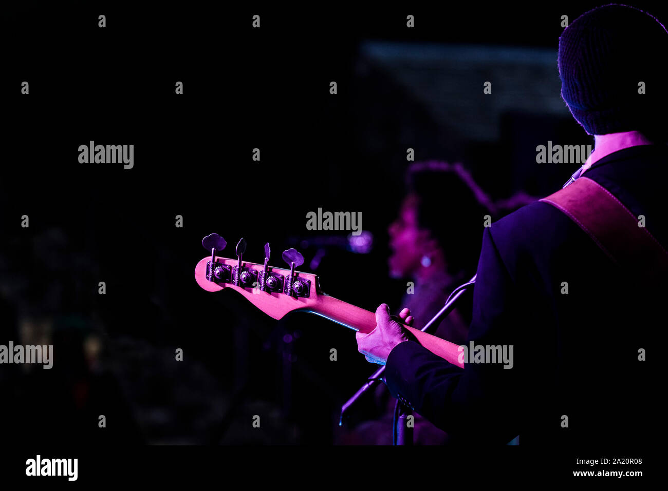 Die Kopfplatte und Stimmschlüssel eines elektrischen Bass von einem Musiker gespielt wird. Stockfoto