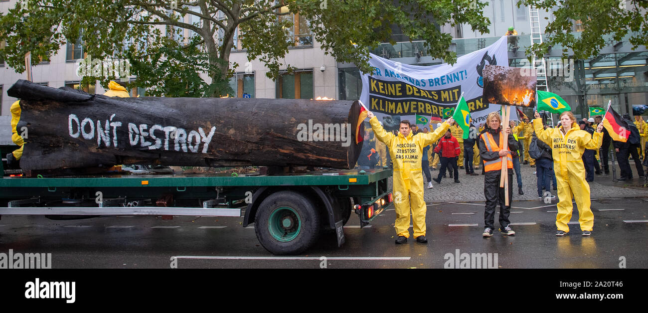 Berlin, Deutschland. 30 Sep, 2019. Anlässlich des Besuchs des brasilianischen Umweltministers Salles, Aktivisten von Greenpeace vor dem Haus der deutschen Wirtschaft neben einer brennenden Baumstamm mit der Aufschrift "Keine zerstören" demonstrieren. Credit: Monika Skolimowska/dpa-Zentralbild/dpa/Alamy leben Nachrichten Stockfoto