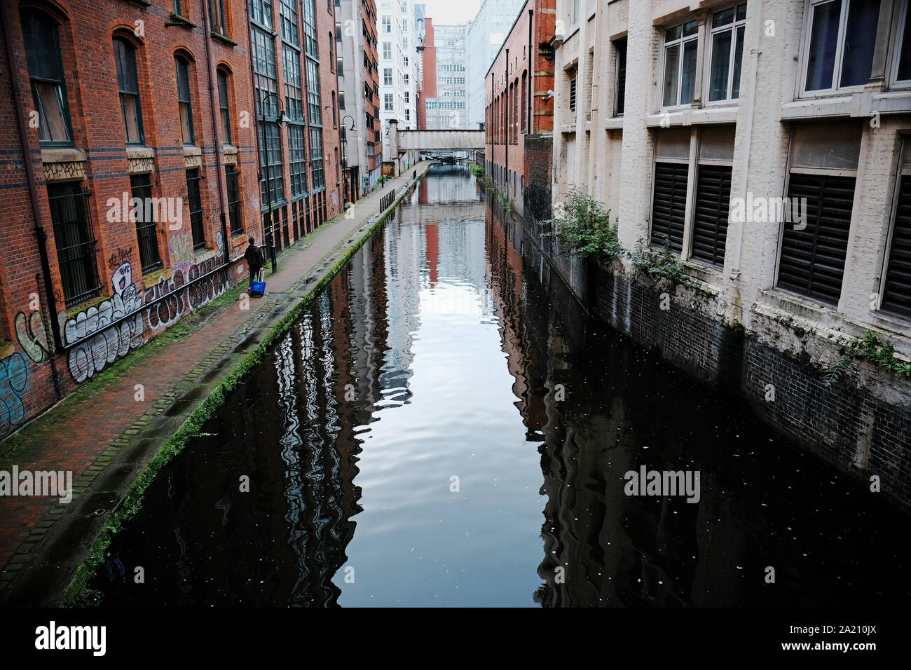 Manchester, UK ein fussgänger Spaziergänge entlang der Rochdale Canal Treidelpfad vorbei durch die Innenstadt. Stockfoto