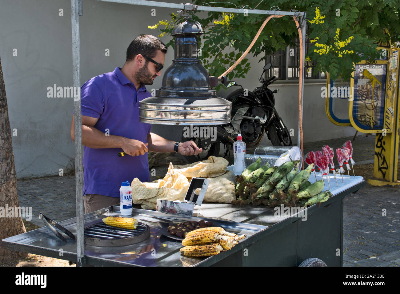 Athen, Griechenland, 04.Juni 2016. Eine street Hersteller von frisch gebackenem Mais wartet auf Käufer zu kommen. Stockfoto