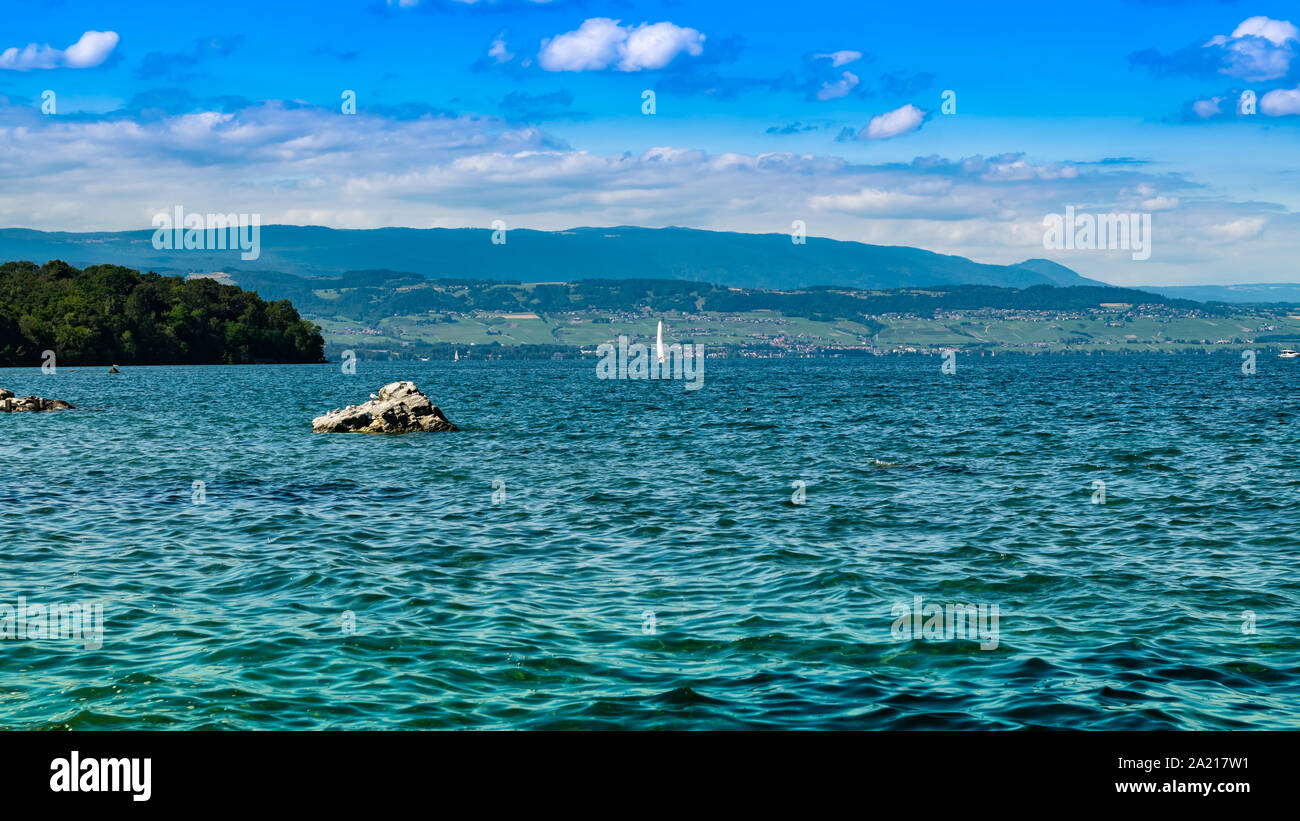 Landschaft Blick auf den Genfer See (Genfer See), Segeln, Boote, Berge und blauer Himmel mit weißen Wolken, Schärfenebene im Zentrum. Excenevex Stadt, Frankreich. Stockfoto