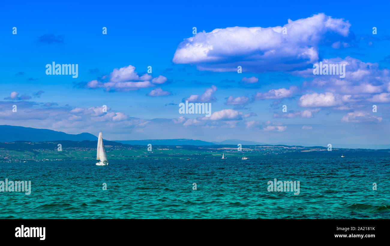 Landschaft Blick auf den Genfer See (Genfer See), Segeln, Boote, Berge und blauer Himmel mit weißen Wolken, Schärfenebene im Zentrum. Excenevex Stadt, Frankreich. Stockfoto