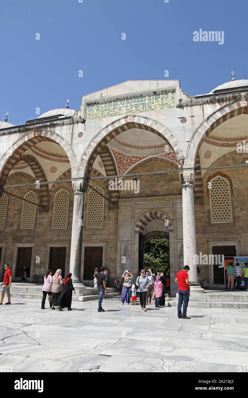 Touristen unter arch mit Kalligraphie Plakette, im Innenhof der Blauen Moschee, Fatih, Istanbul, Türkei. Stockfoto