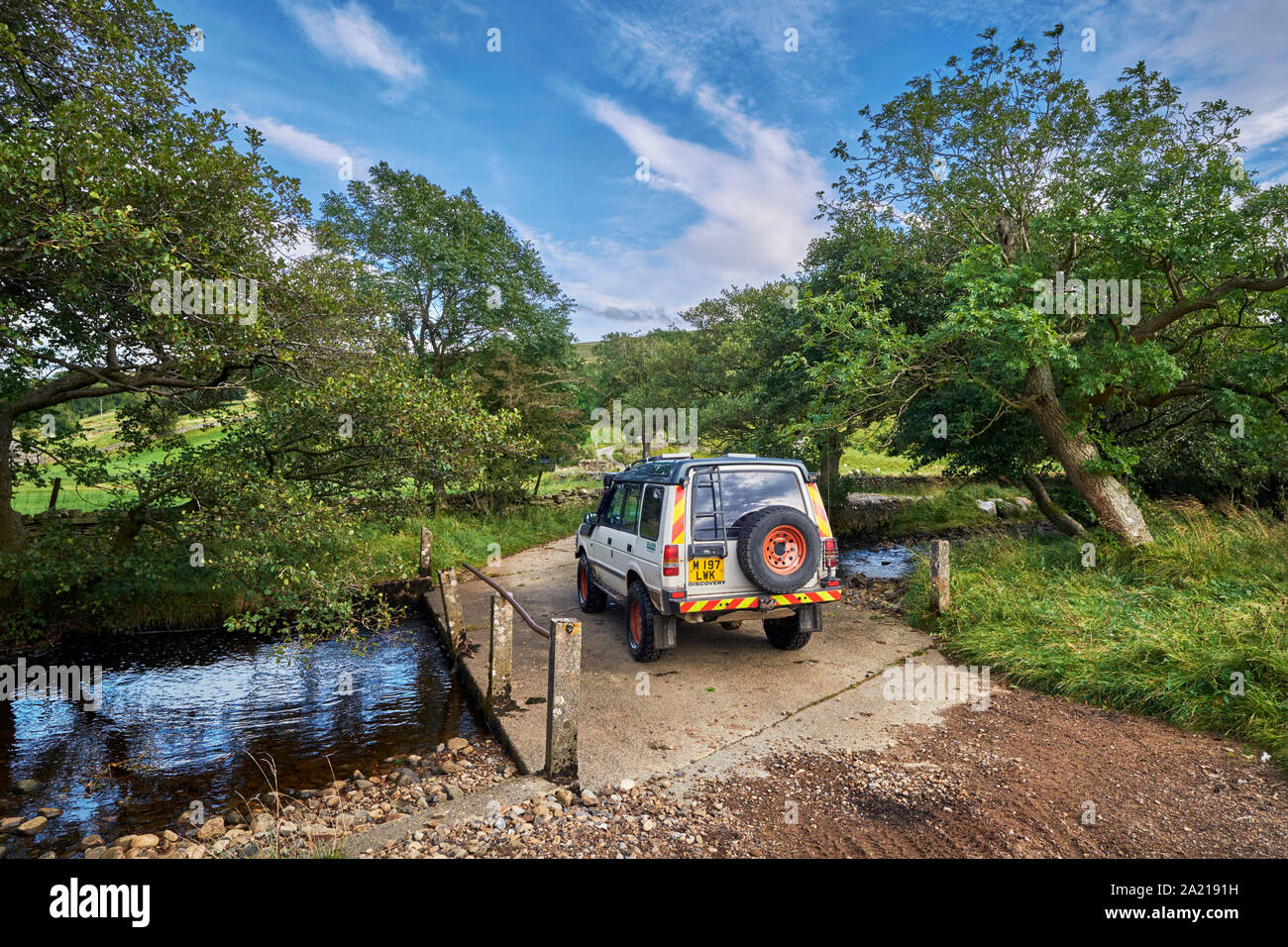 Auto überqueren Brücke über einen Bach. In der Nähe von Marsett, Yorkshire Dales National Park, England. Stockfoto