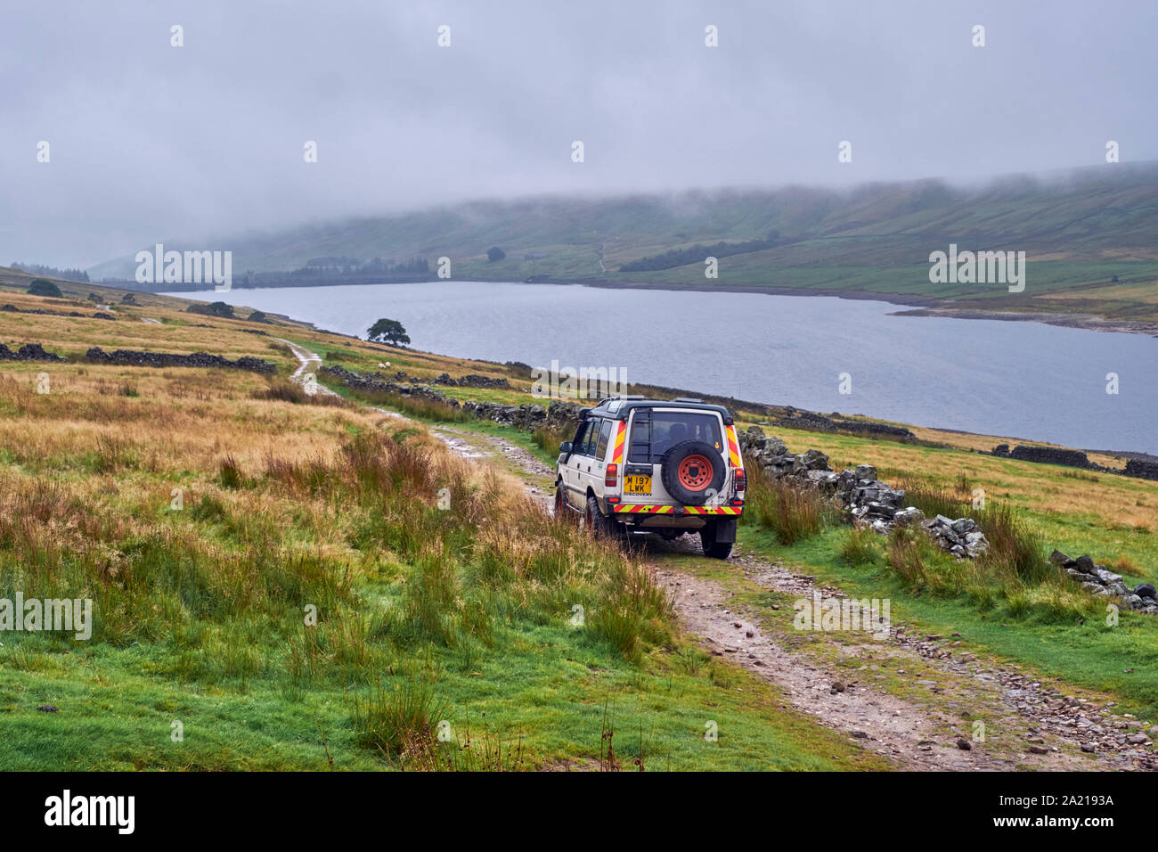 Auto auf unbefestigte Straße durch die Narbe Haus Behälter. Yorkshire Dales National Park, England. Stockfoto