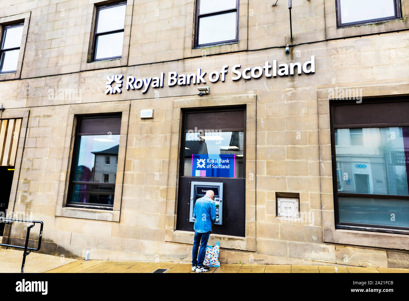 Mann mit Royal Bank of Scotland cashpoint Maschine, Berwick upon Tweed, Northumberland, Großbritannien, England, ATM, Geldautomat, Royal Bank of Scotland, logo Stockfoto