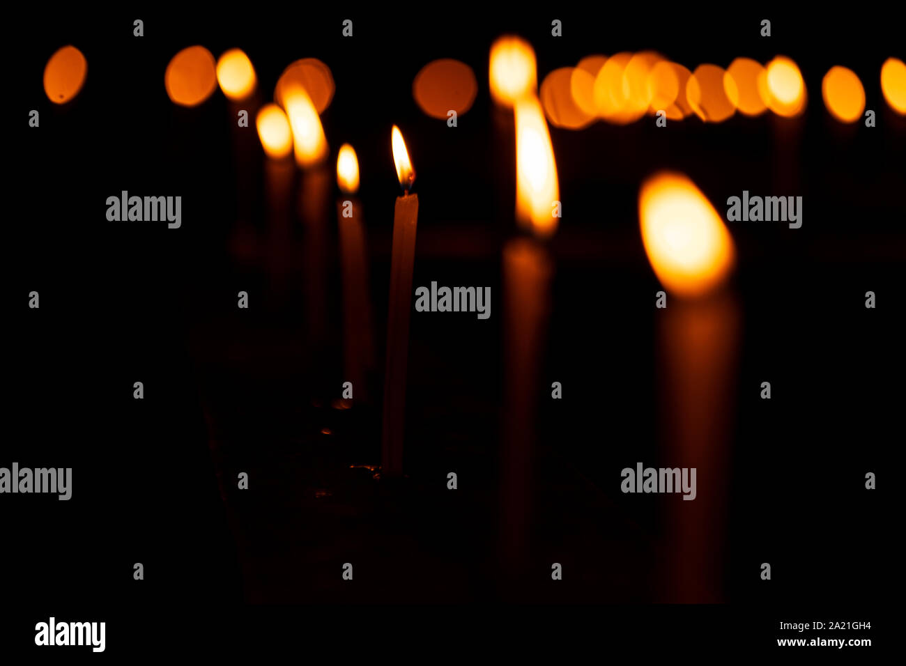 Brennende Kerzen mit einer geringen Tiefenschärfe Kerzenlicht Hintergrundbild für diwali festliche Dekoration oder Kirche Feier am Abend mit kopieren. Stockfoto