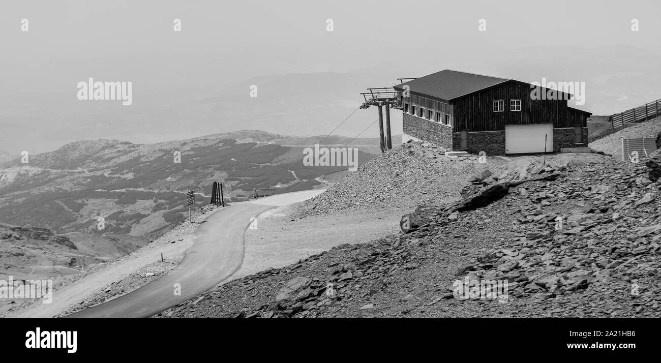 Ein schwarz-weiß Bild von einem Skilift entfernt in der Sierra Nevada mit Blick auf die Landschaft. Stockfoto