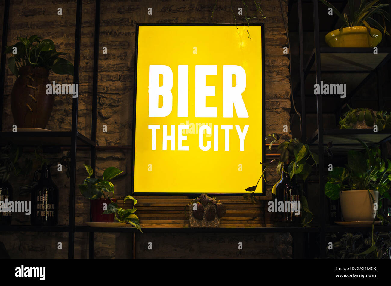 Dekoration eines Handwerk Bier in Sevilla. Leuchtende Banner mit dem Text "Bier der Stadt. Flaschen mit Text 'DRink, Füllen und wiederholen' Stockfoto