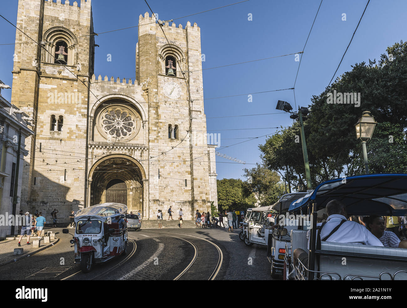 Lissabon, Portugal - August 2019: touristische Tuktuk vorbei an der Straße mit Kopfsteinpflaster vor der Kathedrale im Stadtteil Alfama Stockfoto