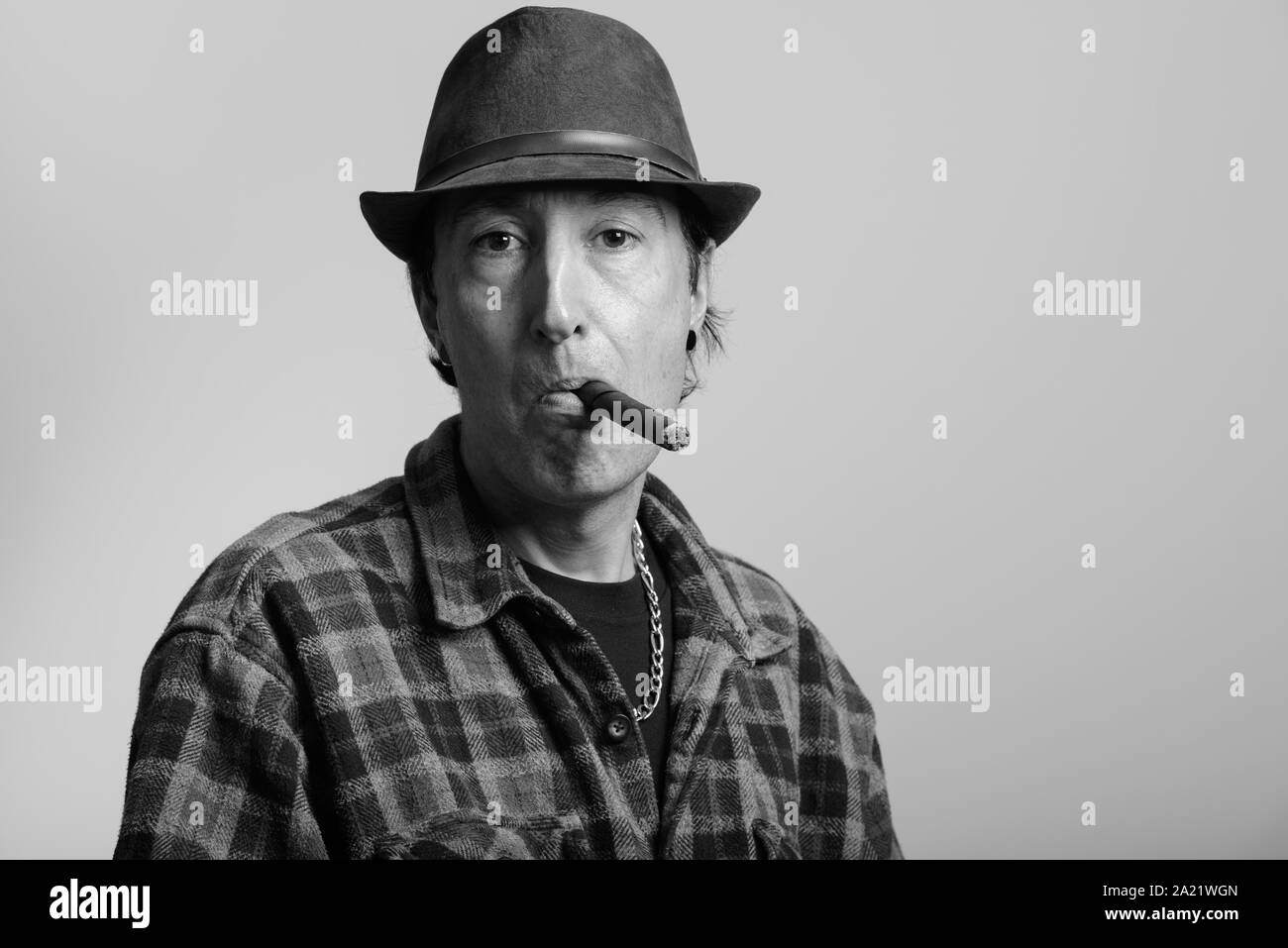 Studio shot reifer Gangster Mann rauchen Zigarre Stockfoto