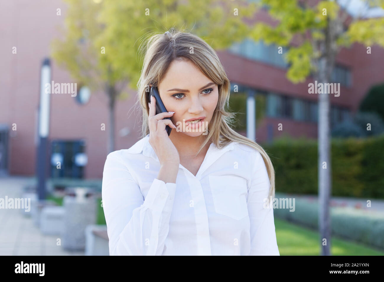 Ernsthafte blond Manager Frau Porträt der Aufruf in Park Stockfoto