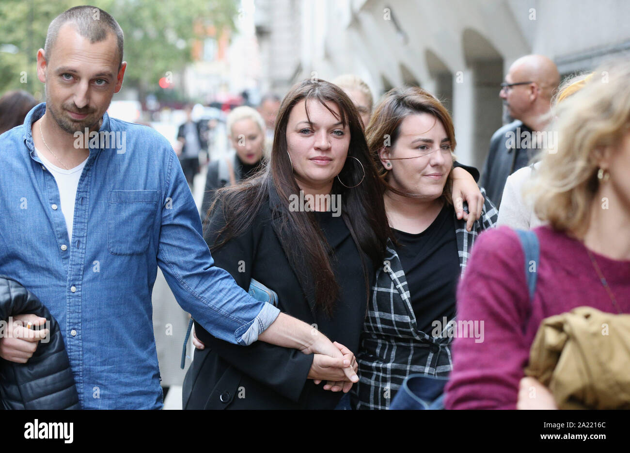 Samantha Collot (Mitte), ein Freund von laureline Garcia-Bertaux ist getröstet von Freunden außerhalb des Old Bailey in Central London nach Kirill Belorusov wurde schuldig seinen französischen Filmproduzenten ex - Freundin Ermordung gefunden. Stockfoto