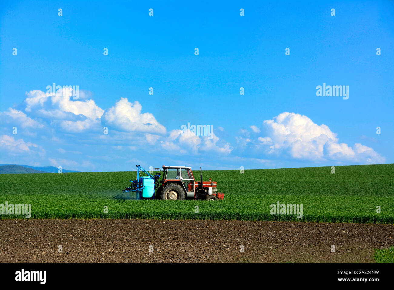 Den Traktor in einem Bereich Landwirtschaft, Auvergne, Frankreich Stockfoto