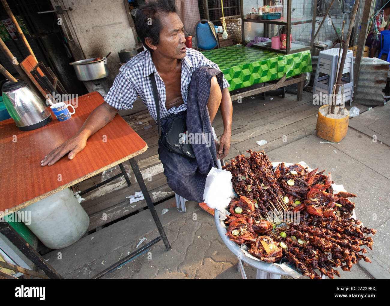 Die burmesische vorbereitet und verkauft traditionelles Essen auf der Straße von Yangon. Stockfoto