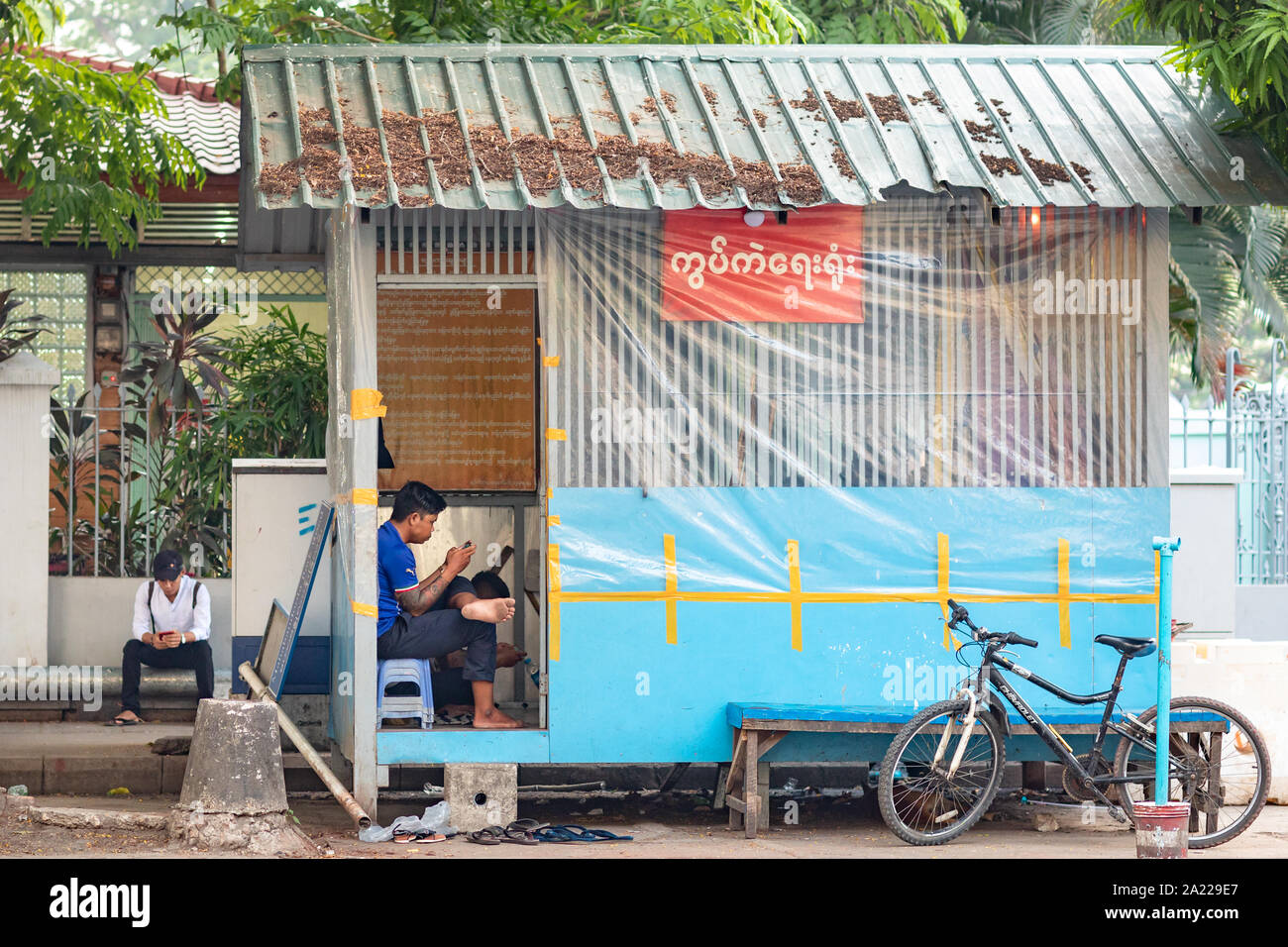 Die Menschen auf der Straße von Yangon mit zellulären Mobil Telefon. Armes Land und moderne Technik Konzept. Moderne Kommunikations-Technologie in der Dritten Welt. Stockfoto
