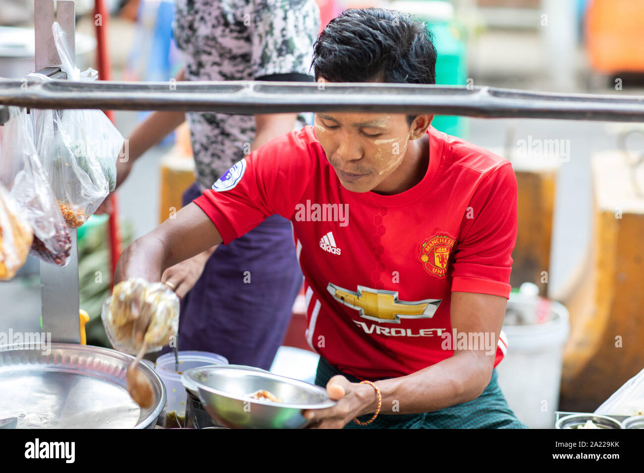 Die burmesische vorbereitet und verkauft traditionelles Essen auf der Straße von Yangon. Stockfoto