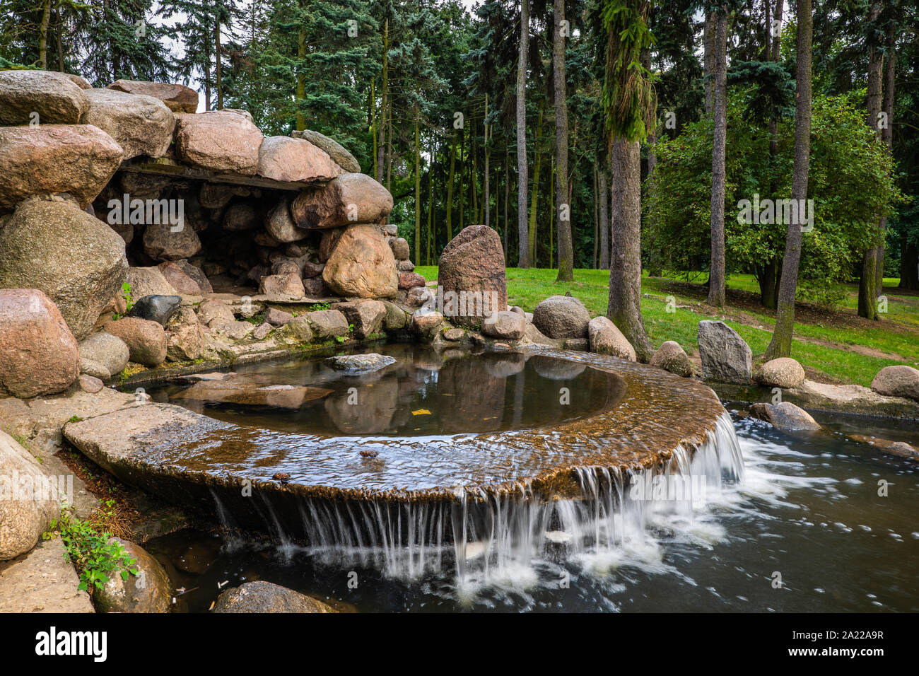 Synthetische gebogene Form Wasserkaskade und kleine Höhle in der skaryszewski Park, Warschau, Polen. Stockfoto