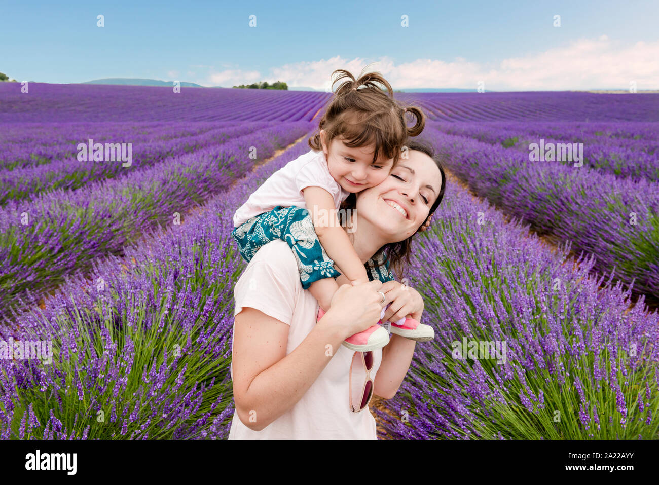 Glückliche Frau und kleines Mädchen zu Fuß unter Lavendelfelder im Sommer Stockfoto