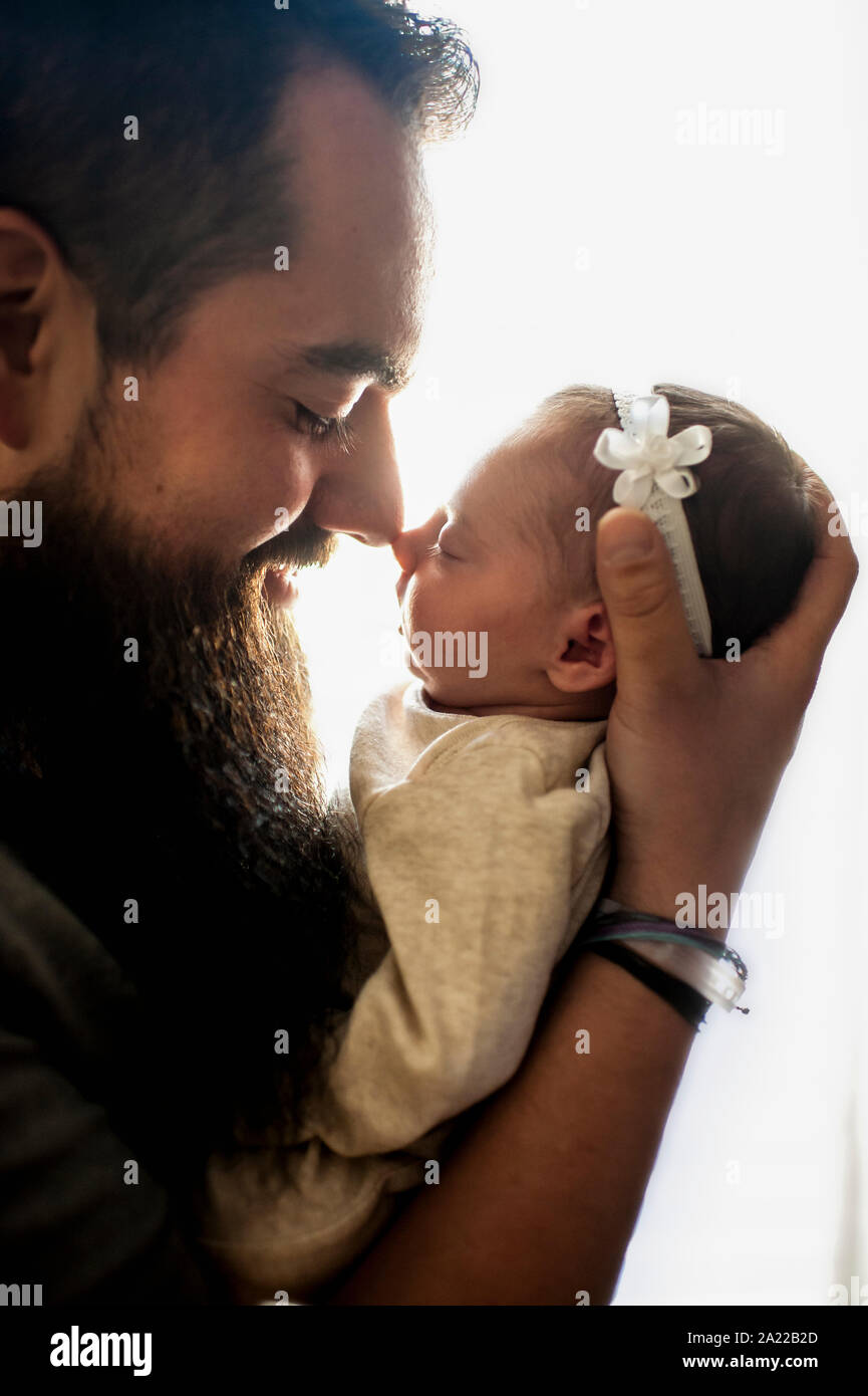 Profil von Vater und neugeborenen Tochter berühren Nasen in hübsches Licht Stockfoto