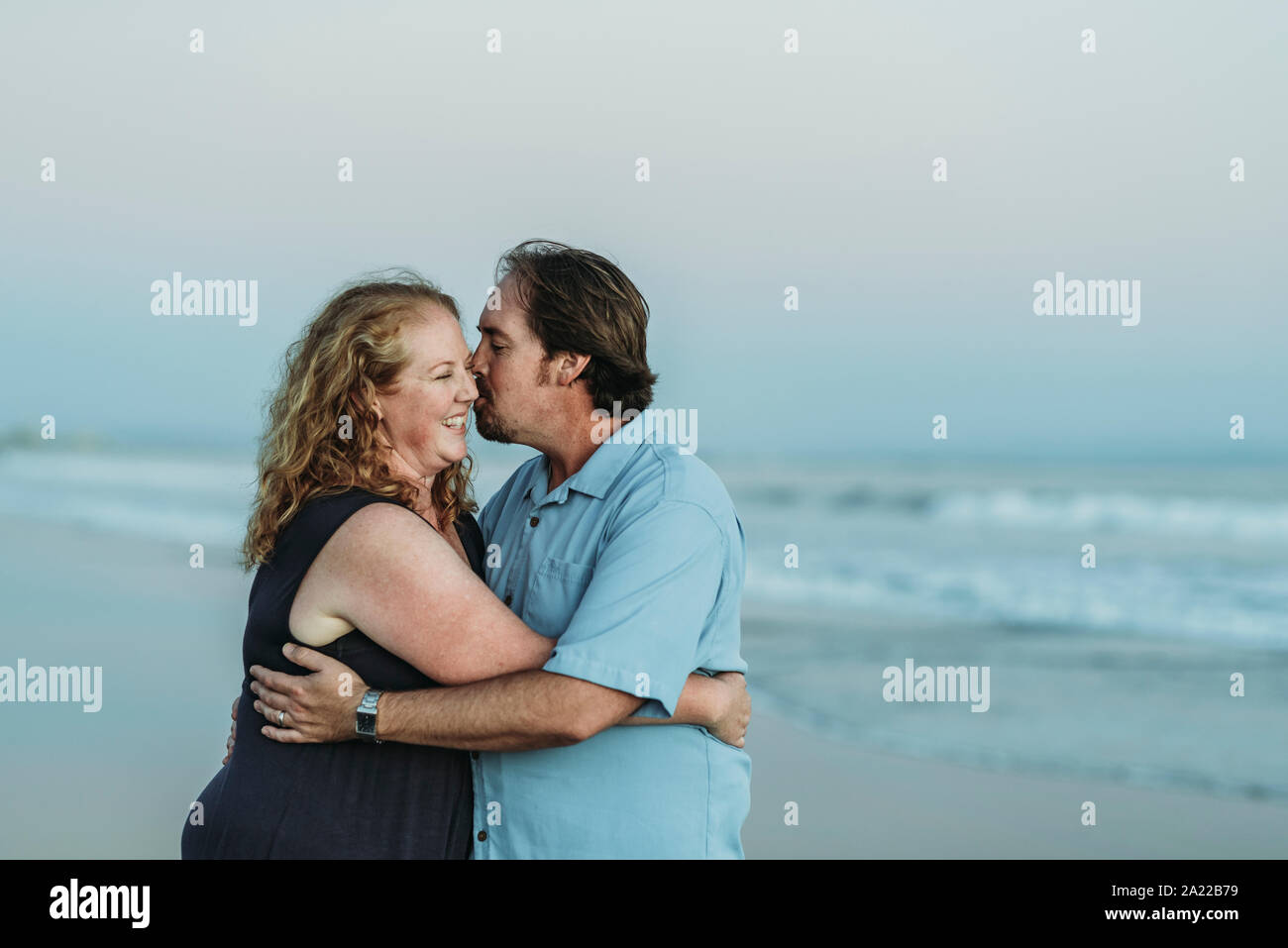 Seitenansicht von Mann und Frau küssen einander am Strand Stockfoto
