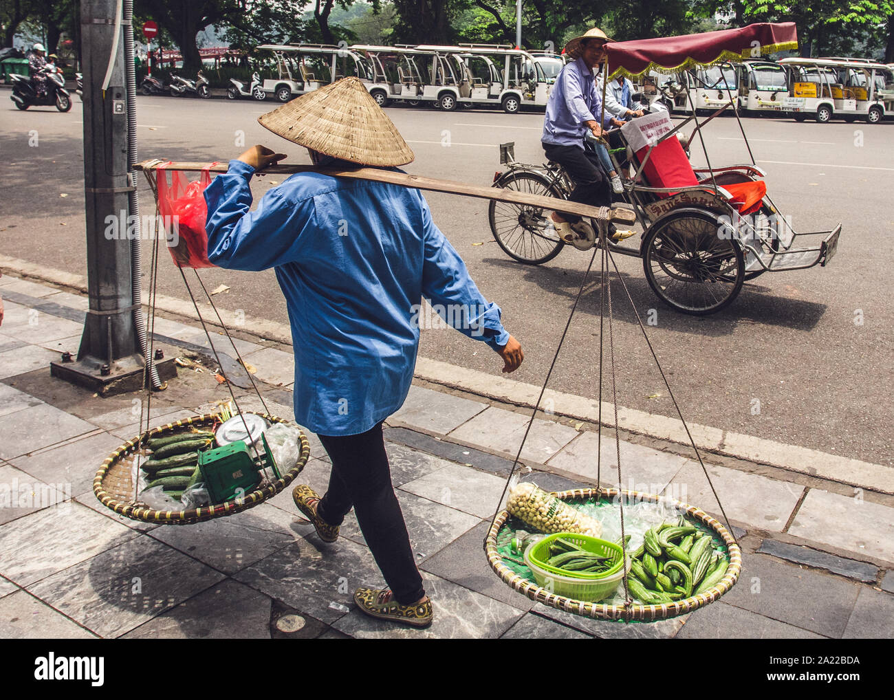 Traditionelle Szene auf der Straße in Hanoi, Vietnam. Street Food Verkäufer und Tuk Tuk auf der Straße in Vietnam. Stockfoto