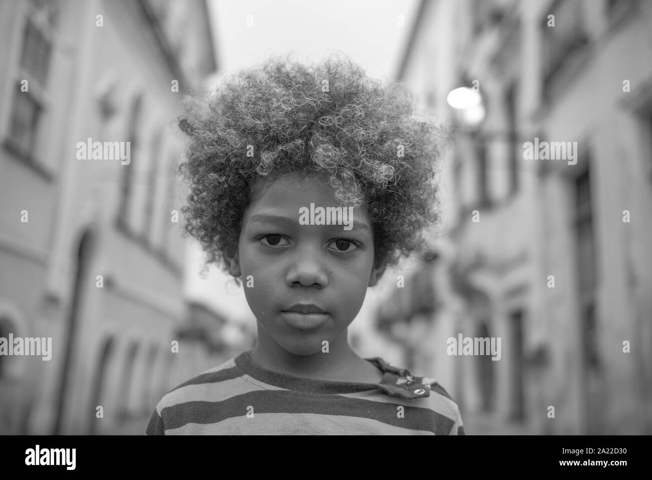 Schöne afro-brasilianische Junge mit lockigem Haar in den Straßen Stockfoto