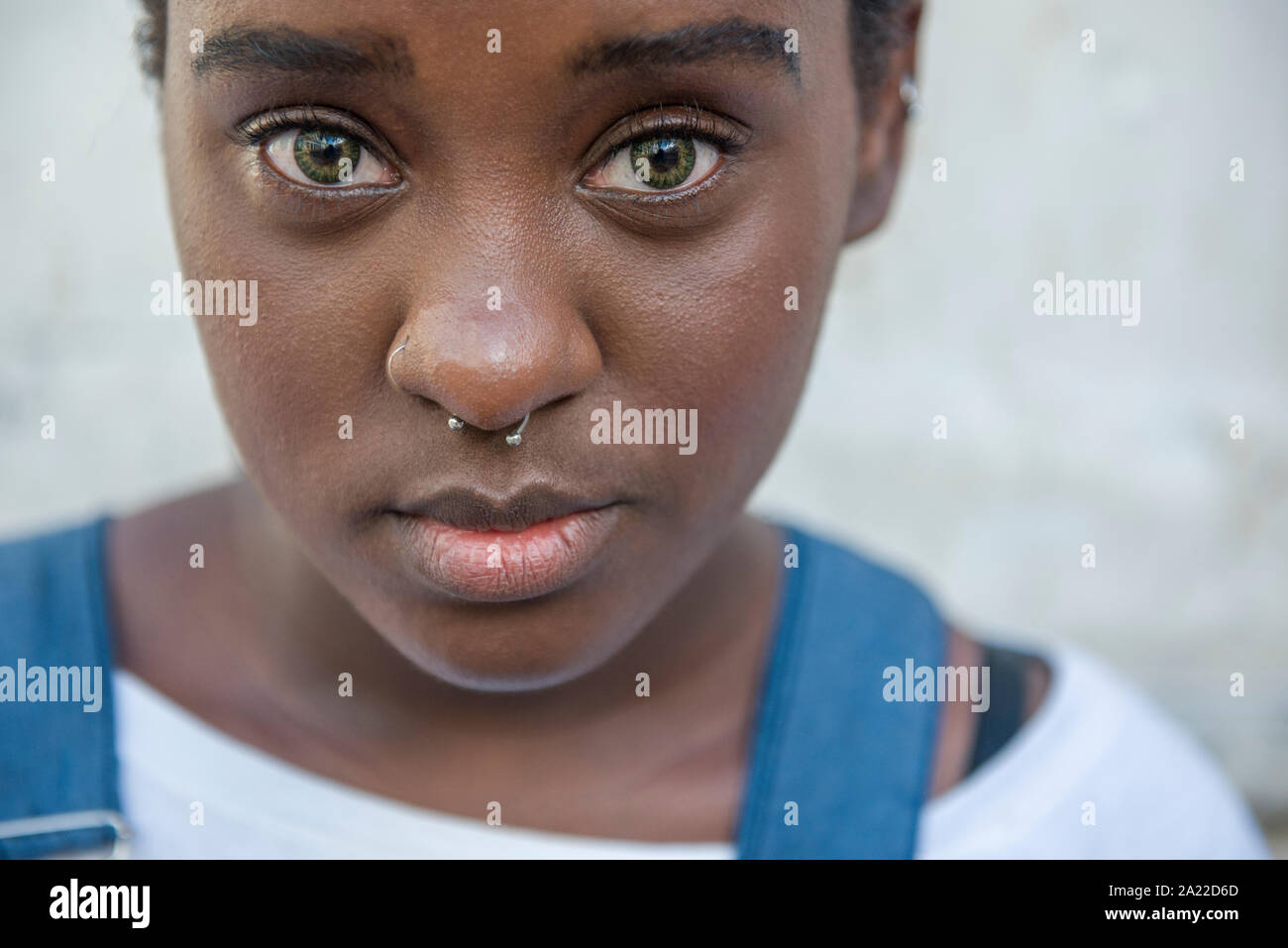 Afro-brasilianischen Mädchen mit grünen Augen trägt Overall Stockfoto