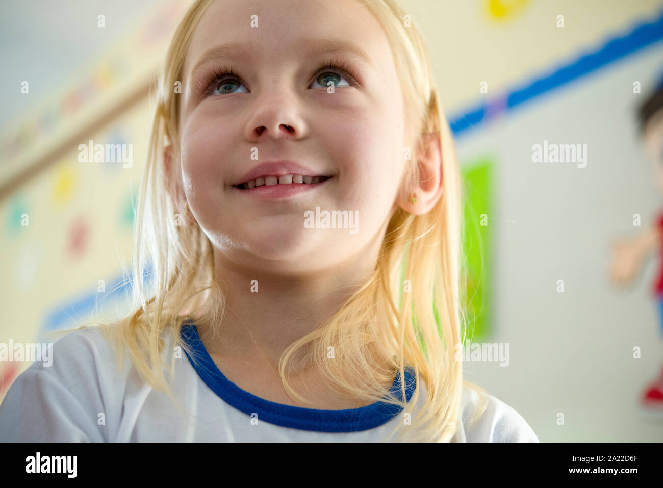 Süße kleine blonde Mädchen in der Schule, lächelnd Stockfoto