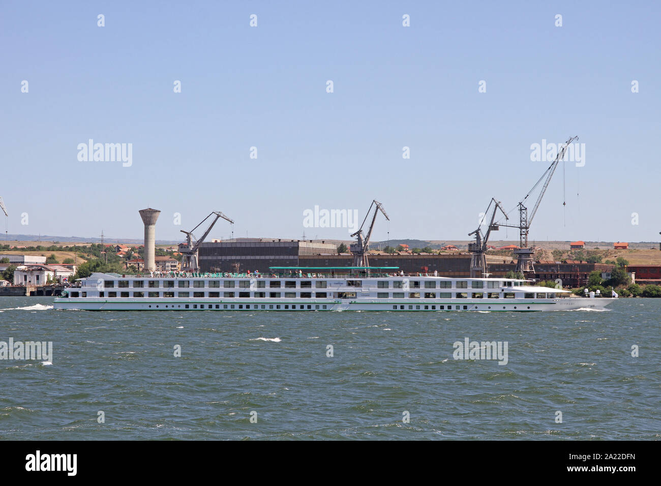 Blick auf Kreuzfahrtschiff, Verladerampe und Krane auf dem rumänischen Bank der Danbe Fluss, Ansicht von Kladovo, Serbien, die Grenze zwischen Rumänien und Serbien, Severin, Rumänien. Stockfoto