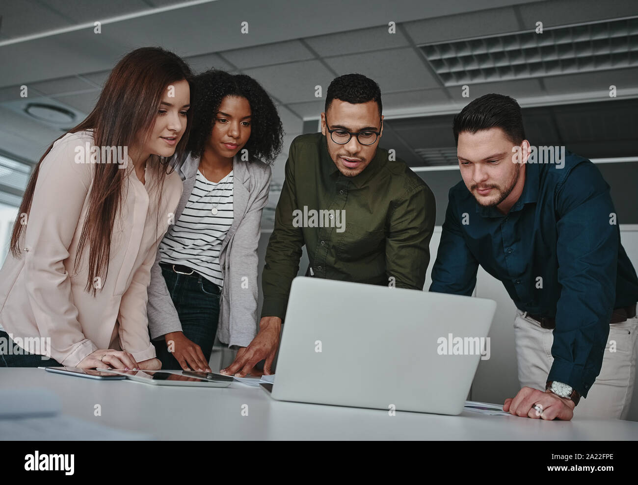 Gruppe von Zusammengeschlossenen diverse Business Team diskutieren, Informationen über Laptop Bildschirm über den Schreibtisch im Büro Stockfoto