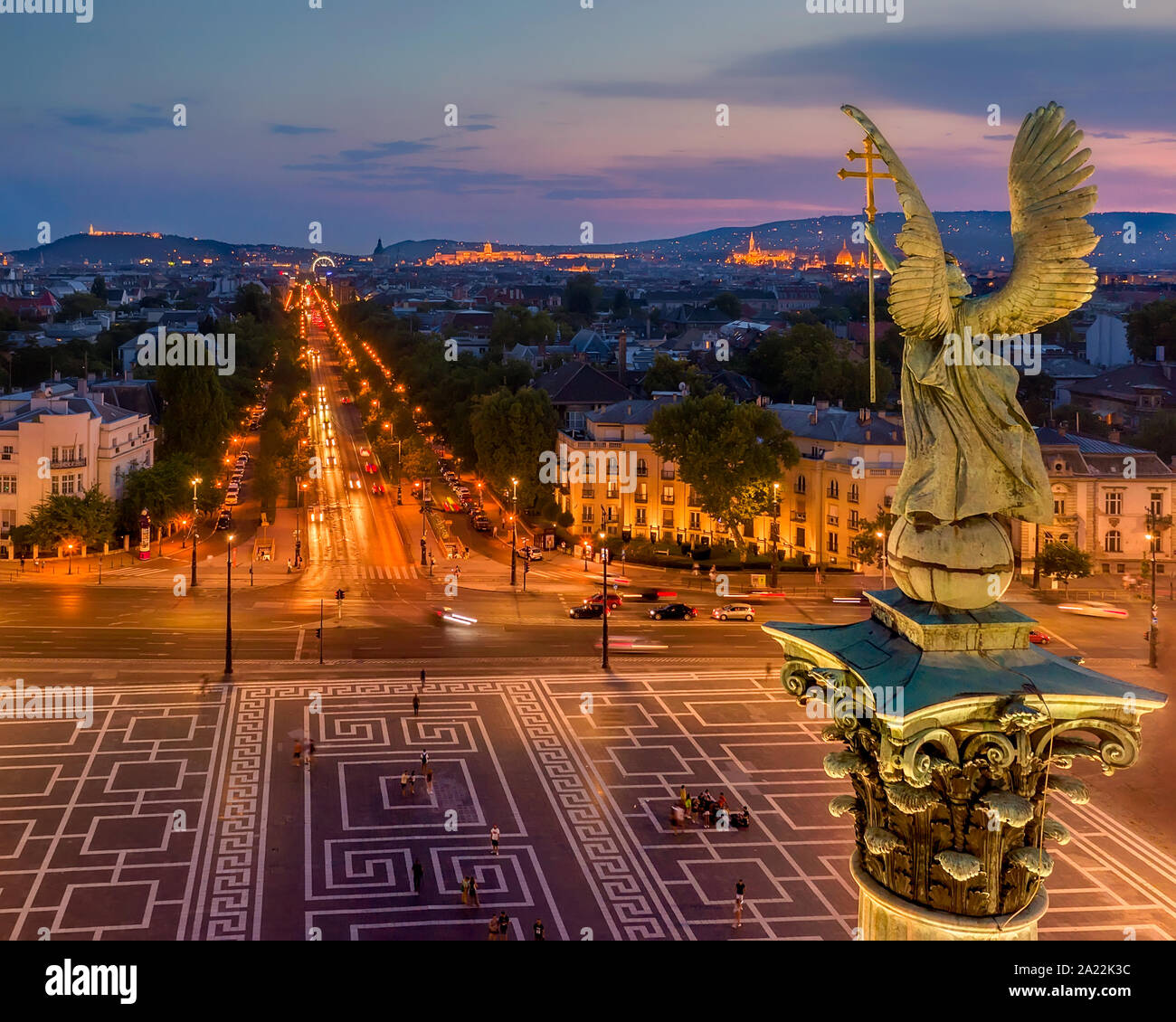 Andrassy Straße und Gabriel Arkangel in Budapest mit den Lichtern der Stadt. Sonnenuntergang Stimmung. Europa, Ungarn, Heldenplatz Stockfoto