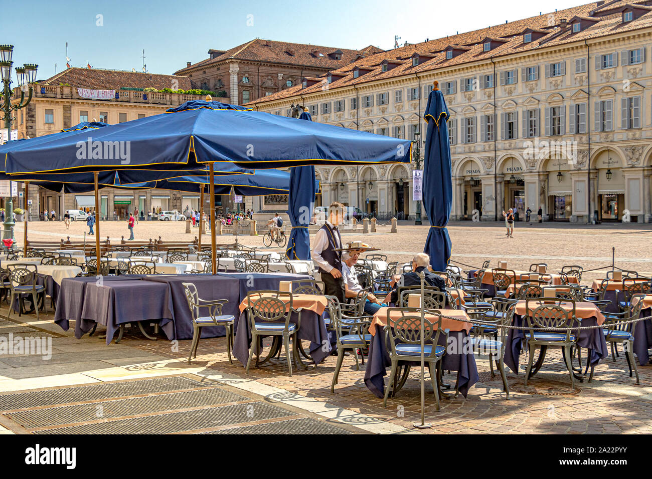 Ein Kellner serviert Kaffee in einem Restaurant auf der eleganten barocken Piazza San Carlo, einem der wichtigsten Plätze der Stadt, Turin, Italien Stockfoto