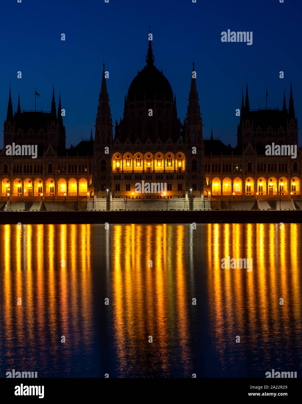 Parlament in Budapest, Ungarn. Berühmte Sehenswürdigkeiten, historische Gebäude. Blaue Stunde und Gelb leuchten, was in Donau wider. Stockfoto