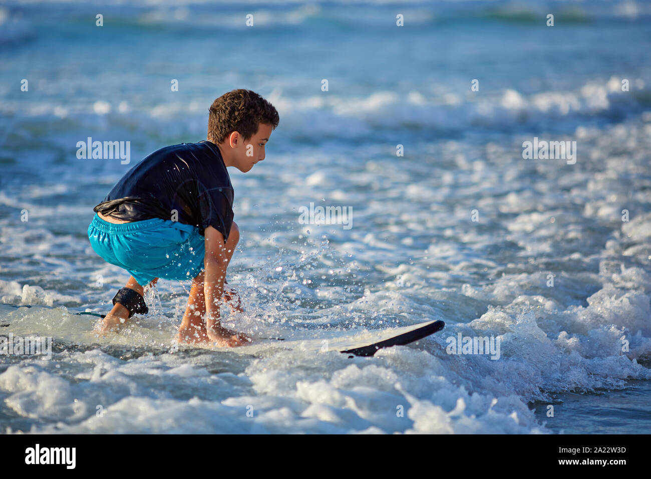 Qualifizierte Teenager, Surfbrett und Balancing eine lange wellige Meer Stockfoto