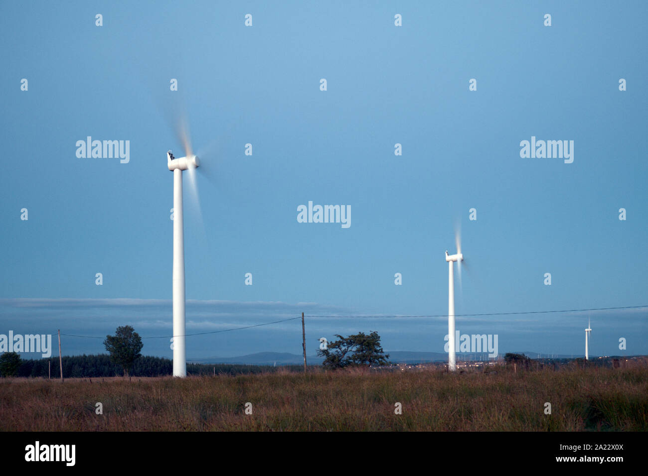 Windmühlen im Feld in den Abend auf dem Hintergrund des blauen Himmels. West Lothian, Schottland, Großbritannien Stockfoto