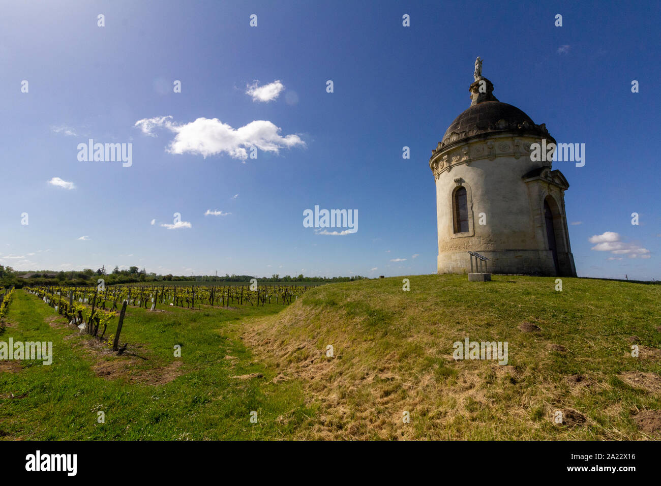 In der Mitte von einem Bordeaux Weinberg gefunden, ein runder Turm Kapelle steht auf einem kleinen Hügel Stockfoto