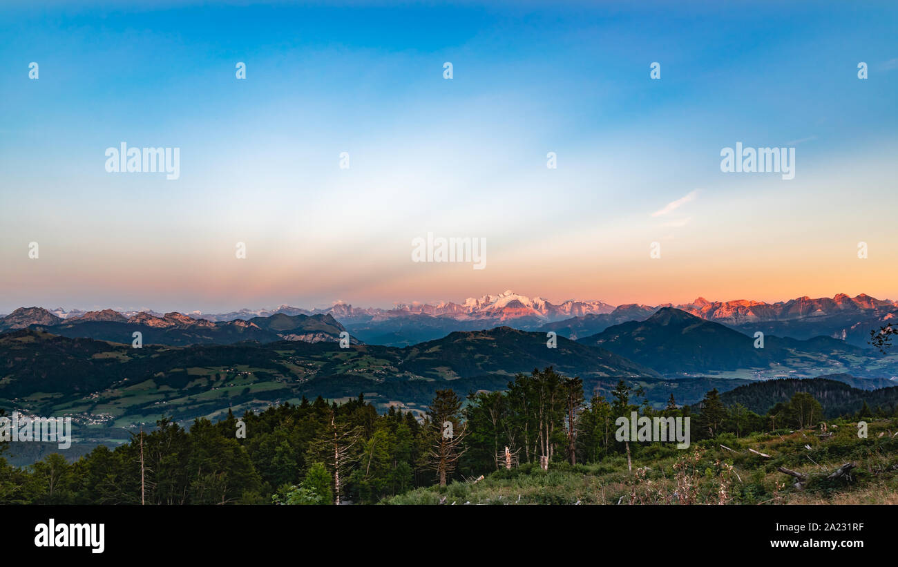 Alpine Landschaft, Mont Blanc Mountain Peak, Mont Blanc Massiv, Savoyer Voralpen, Sonnenuntergang beleuchtet die Berggipfel in Orange. Stockfoto