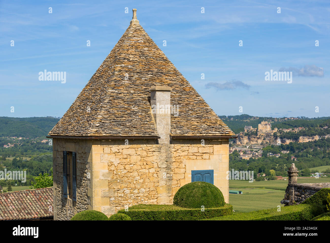 Formgehölze in den Gärten des Jardins de Marqueyssac in der Region Dordogne in Frankreich. Burg von Castelnaud auf der Rückseite. Stockfoto