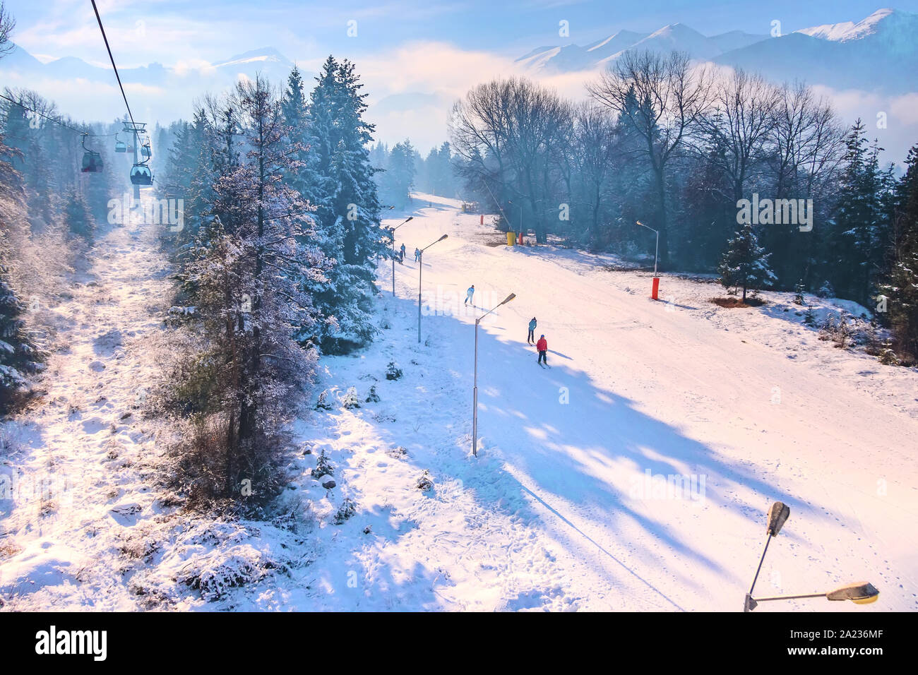 Bansko, Bulgarien Sonnenuntergang Antenne winter Resort view mit Skipiste im Wald, Seilbahn, Gondel Hütten und Berggipfel Stockfoto