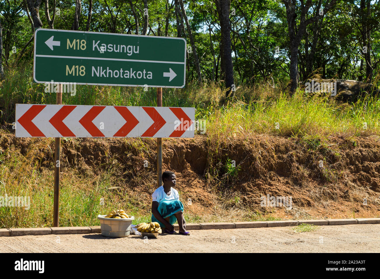 Eine junge Frau verkauft Bananen zu einem Straße Checkpoint in Malawi Stockfoto