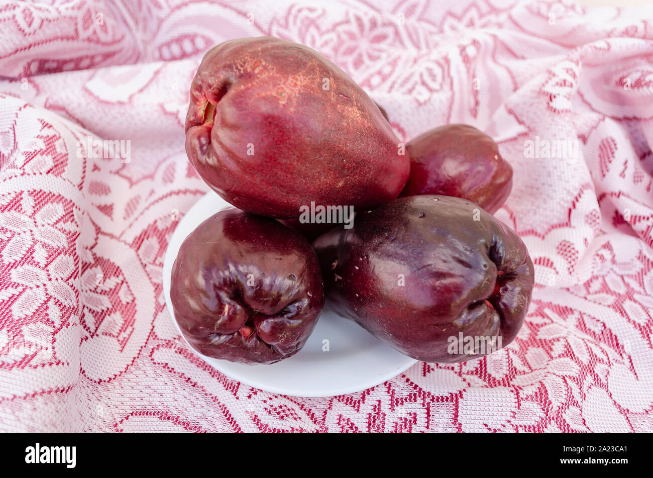 Rote Reife Otaheite Äpfel auf Spitze Tischdecke Stockfoto