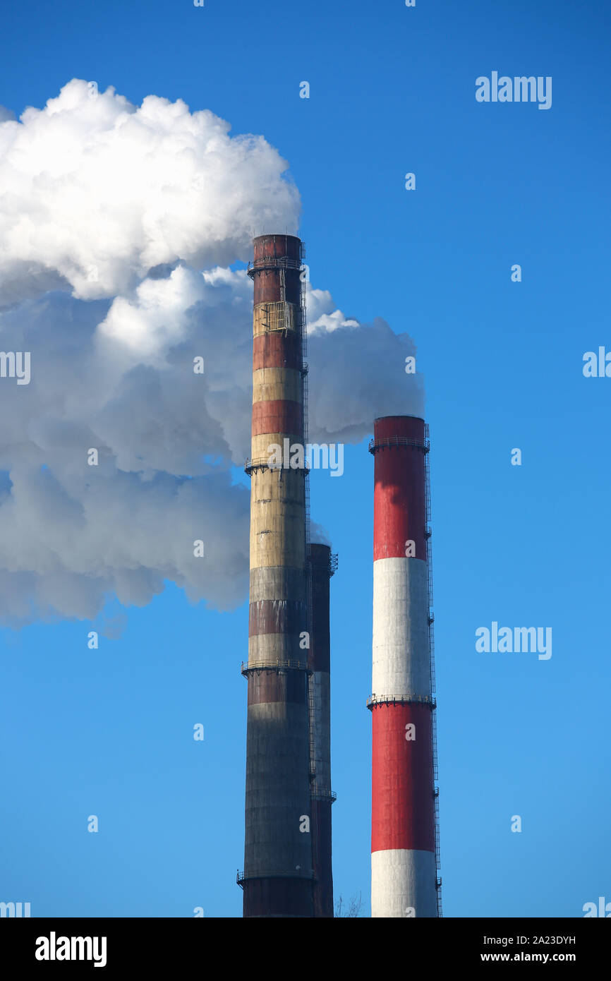 Weißer Rauch kommt aus Rohren gegen den blauen Himmel Stockfoto