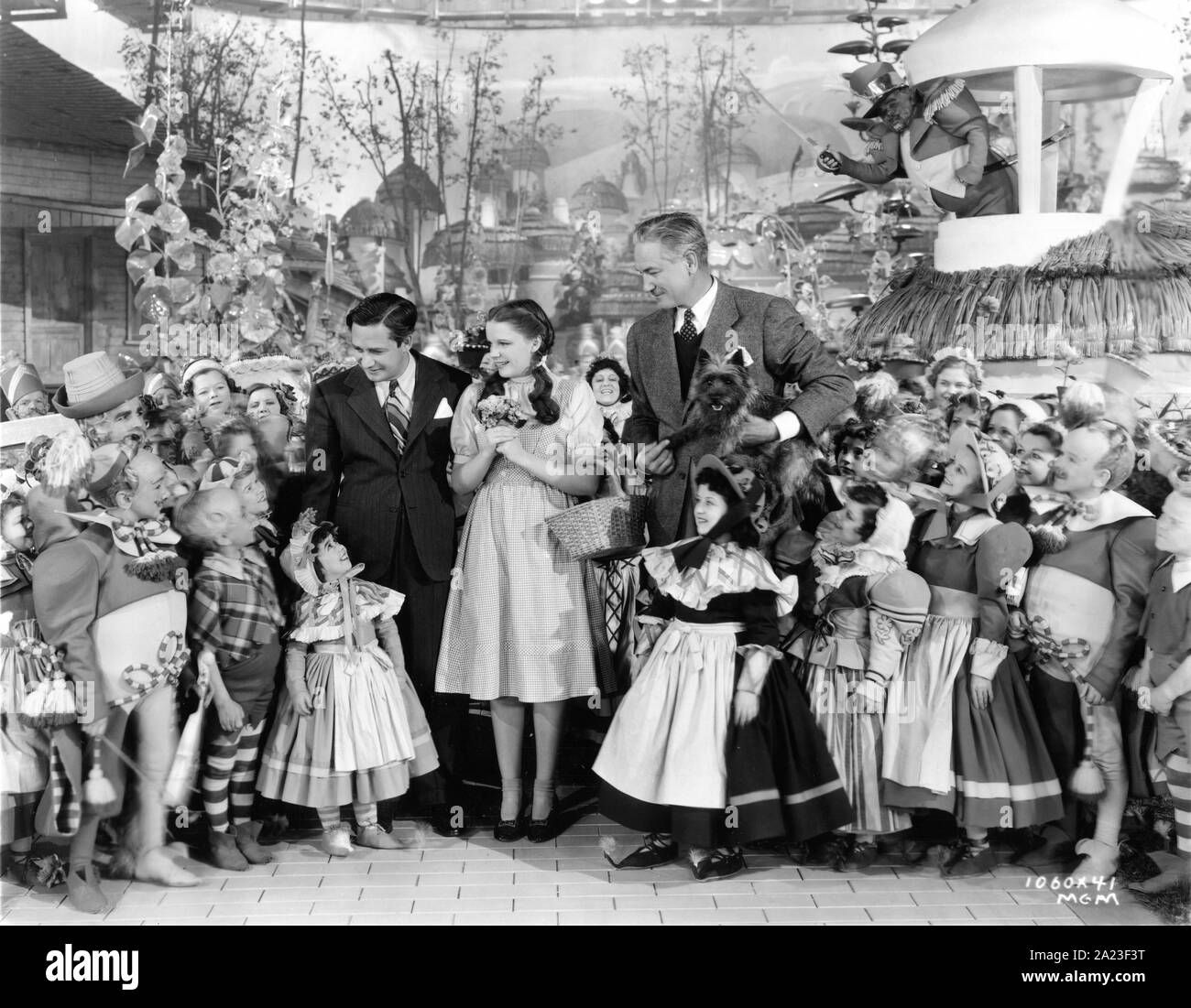 JUDY GARLAND am Set offen Dreharbeiten der Zauberer von Oz 1939 mit Produzent MERVYN LeROY Regie VICTOR FLEMING TOTO die Hund und die MUNCHKINS Kostüme von Gilbert Adrian buch Frank L. Baum Metro Goldwyn Mayer Stockfoto
